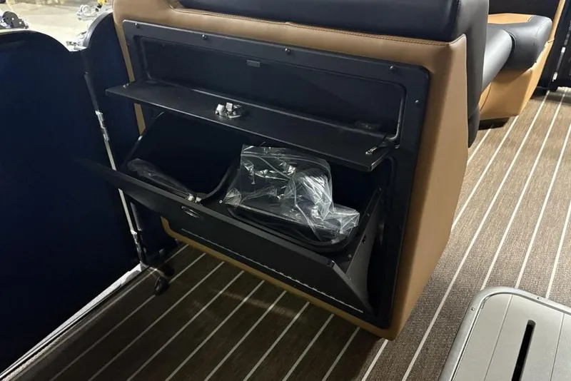 Slide: The Image of Interior storage compartment of 2026 Premier 230 Sunsation RL boat with brown and black seating. - 19
