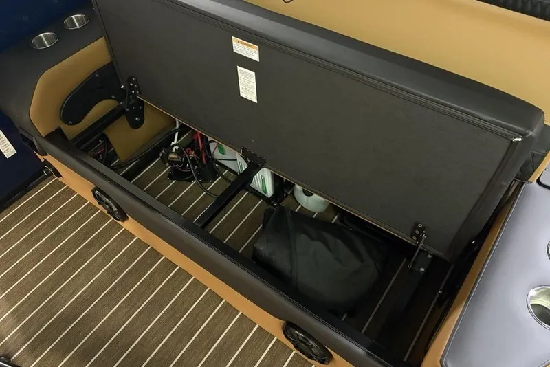 Slide: The Image of Storage compartment of 2026 Premier 230 Sunsation RL boat with open seat and cup holders. - 27