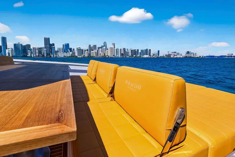 Slide: The Image of Luxurious 2023 Pardo Yachts 43 with city skyline view, featuring elegant seating and wooden table. - 17