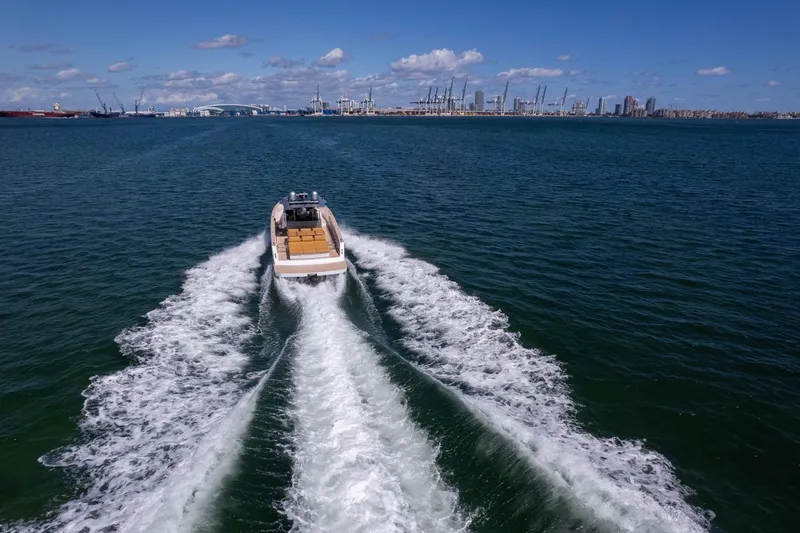 Slide: The Image of 2023 Pardo Yachts 43 cruising on open water with city skyline in background. - 4