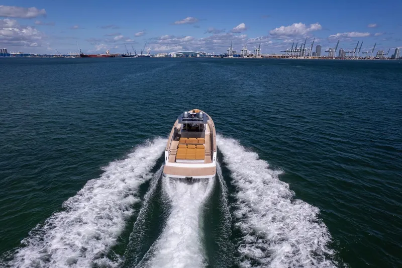 Slide: The Image of 2023 Pardo Yachts 43 cruising on open water with city skyline in background. - 68