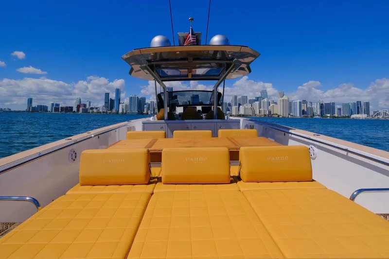 Slide: The Image of 2023 Pardo Yachts 43 with yellow seating, city skyline in background, sunny day. - 14