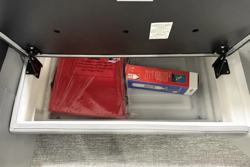 Slide: The Image of Storage compartment in 2026 Premier 230 Solaris RF, containing a red bag and a boxed item. - 33