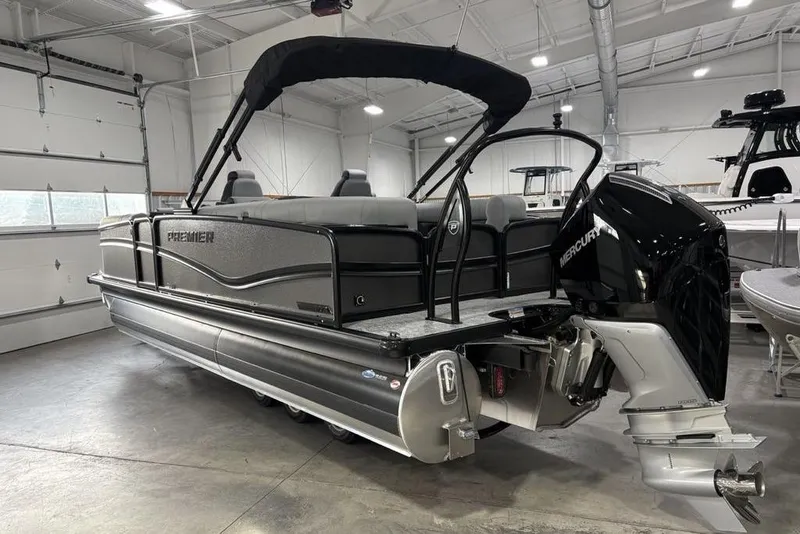Slide: The Image of 2026 Premier 230 Solaris RF pontoon boat in a showroom with Mercury outboard engine. - 7