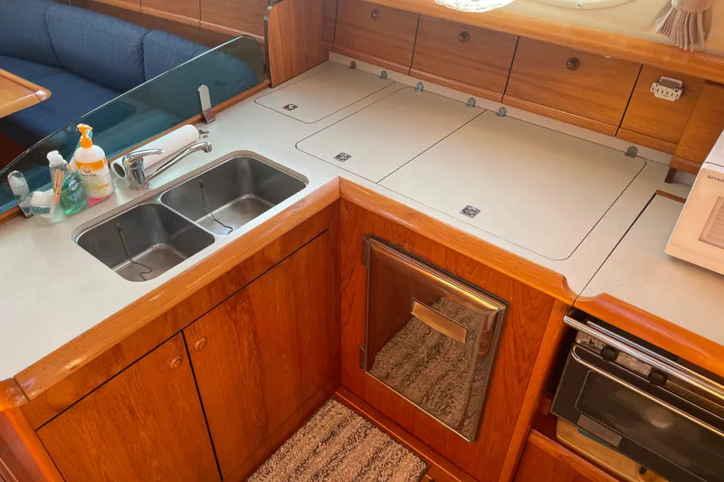Slide: The Image of Modern kitchen in 2003 Jeanneau Sun Odyssey 43 DS yacht with double sink and wooden cabinetry. - 13
