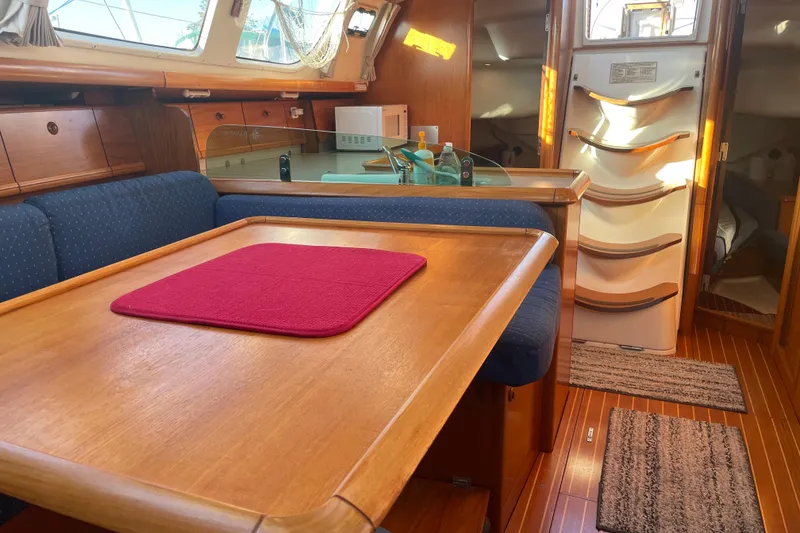 Slide: The Image of Interior of 2003 Jeanneau Sun Odyssey 43 DS sailboat with wooden dining area and blue seating. - 24
