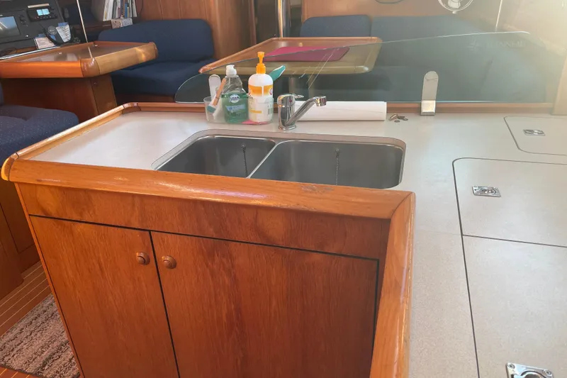 Slide: The Image of Interior of 2003 Jeanneau Sun Odyssey 43 DS yacht, featuring a wooden kitchen area with a sink. - 27
