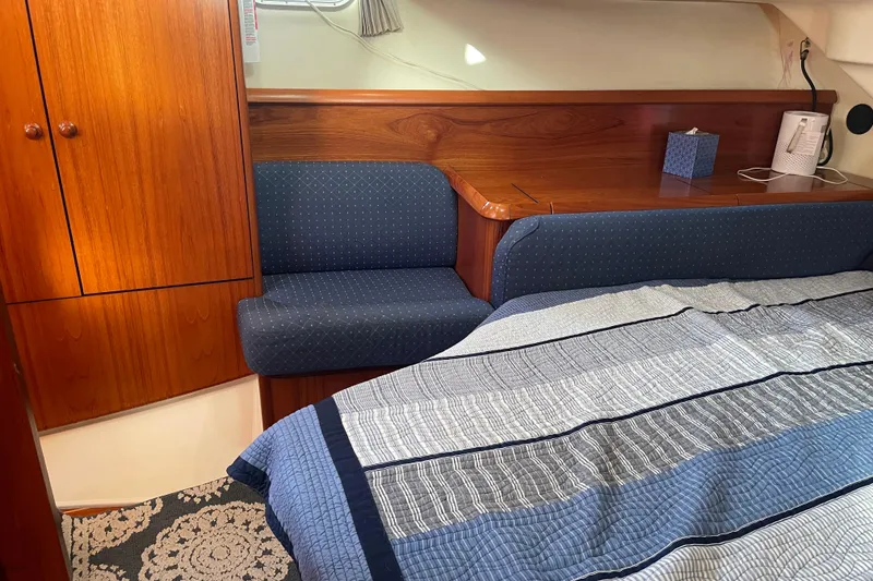 Slide: The Image of Interior cabin of 2003 Jeanneau Sun Odyssey 43 DS with wood paneling and blue upholstery. - 44