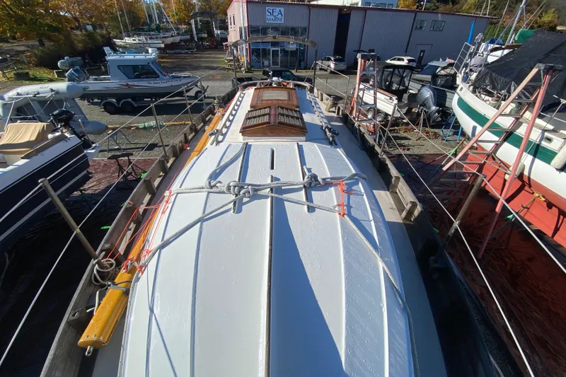 Slide: The Image of 1978 Bristol Channel Cutter 28 sailboat on dry dock, surrounded by other boats. - 11