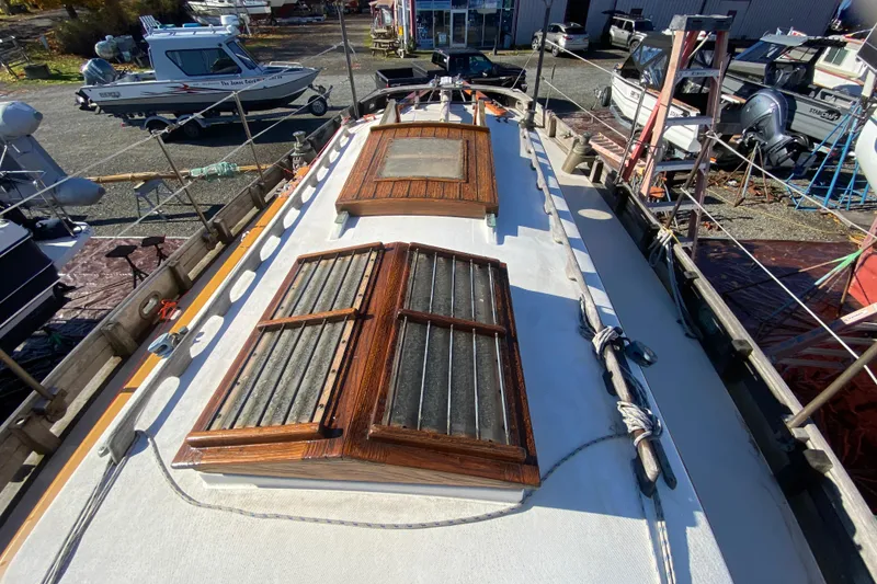 Slide: The Image of 1978 Bristol Channel Cutter 28 sailboat deck with wooden hatches, docked in a marina. - 12