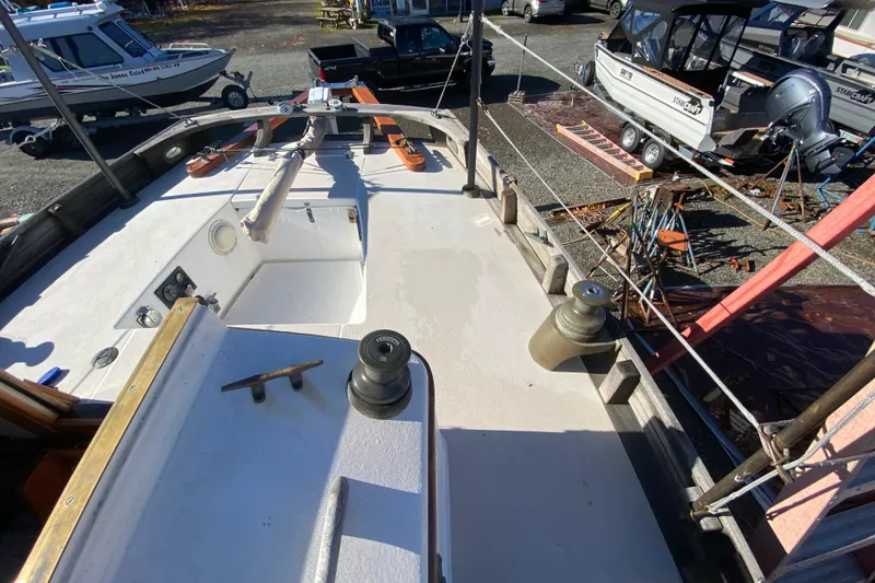 Slide: The Image of 1978 Bristol Channel Cutter 28 sailboat deck with winches and rigging, parked near other boats. - 13
