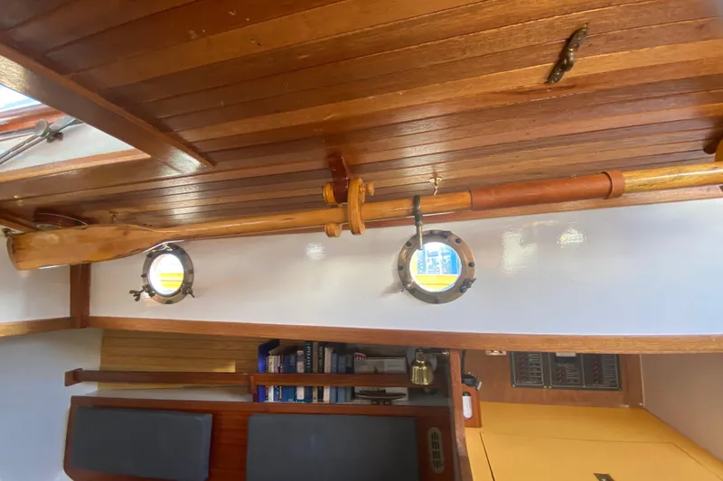 Slide: The Image of Interior of a 1978 Bristol Channel Cutter 28, featuring wooden details and portholes. - 21