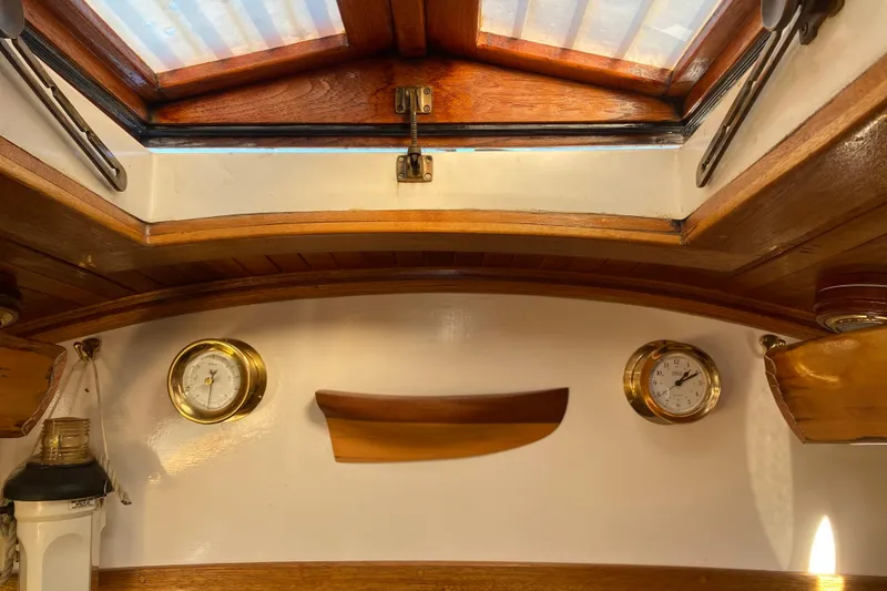 Slide: The Image of Interior of 1978 Bristol Channel Cutter 28 with wooden accents and nautical instruments. - 30