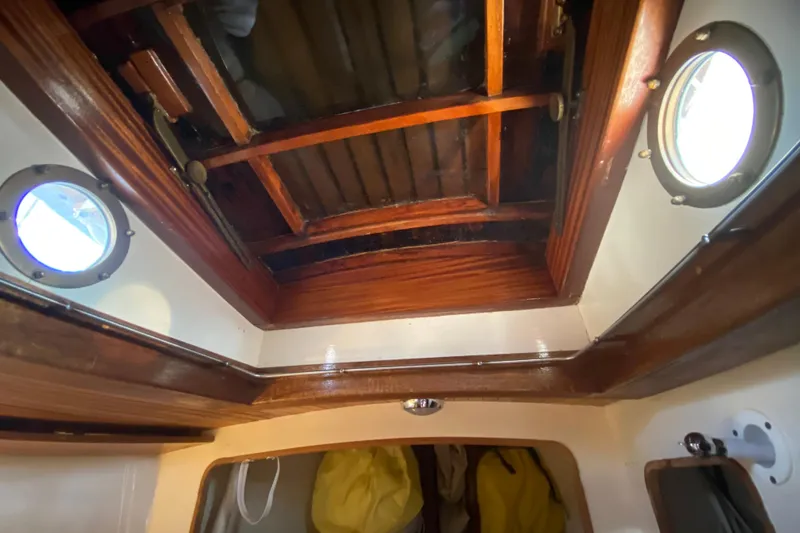 Slide: The Image of Interior view of 1978 Bristol Channel Cutter 28 with wooden ceiling and portholes. - 33