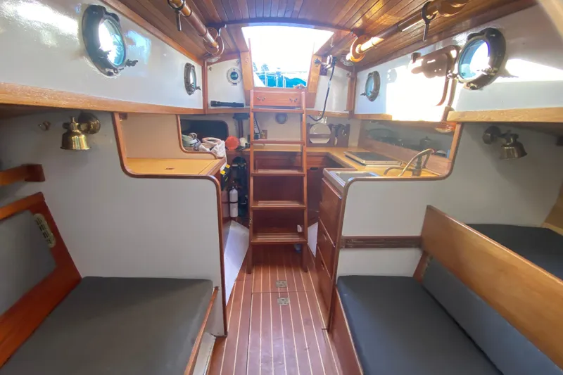 Slide: The Image of Interior of a 1978 Bristol Channel Cutter 28 sailboat, featuring wooden finishes and compact design. - 36
