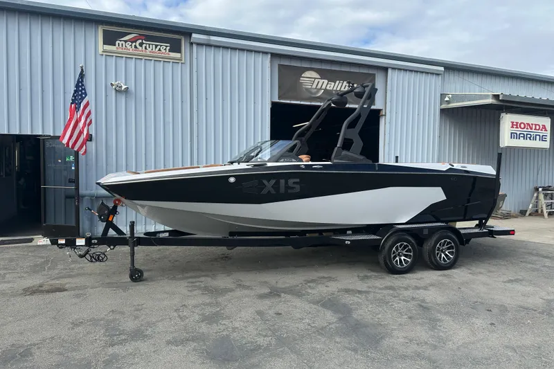 Slide: The Image of 2026 Axis A225 boat on trailer outside marine dealership with American flag. - 1