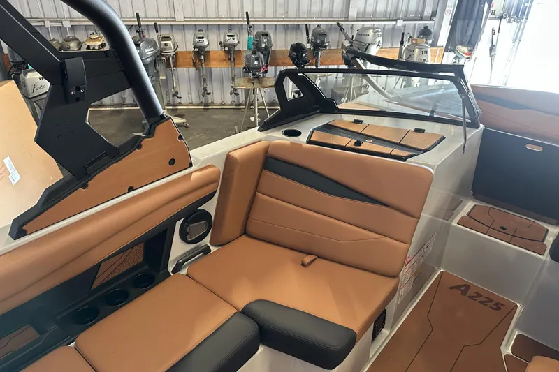 Slide: The Image of 2026 Axis A225 boat interior with tan seating and modern design in a showroom. - 8