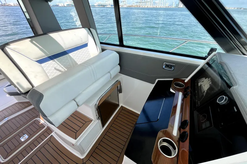 Slide: The Image of 2021 Tiara Yachts 43 LE helm with luxurious seating and modern controls, overlooking the ocean. - 19