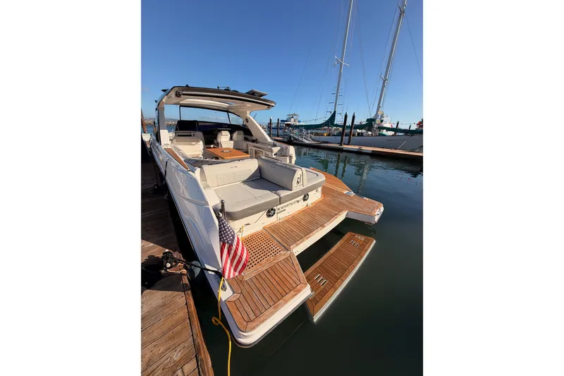 Slide: The Image of 2021 Sea Ray SLX 400 yacht docked, featuring spacious deck and American flag. - 13
