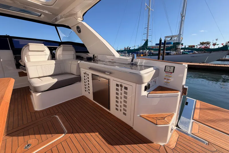 Slide: The Image of Luxurious 2021 Sea Ray SLX 400 yacht interior with seating and kitchenette, docked at marina. - 22