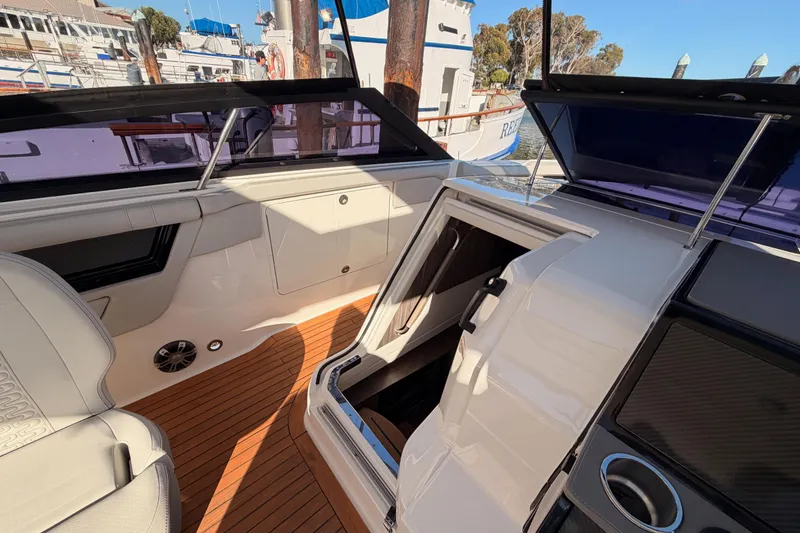 Slide: The Image of 2021 Sea Ray SLX 400 interior with open cabin door, showcasing luxury seating and wood flooring. - 37