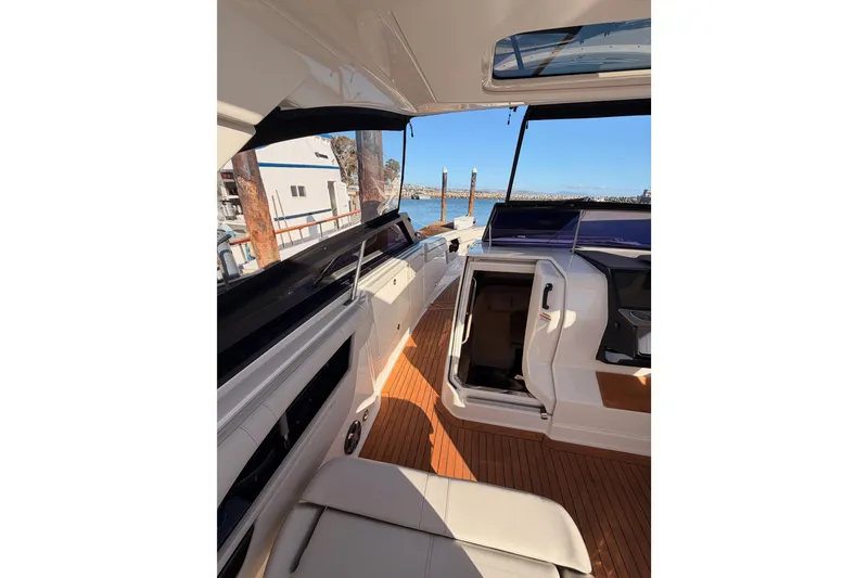 Slide: The Image of 2021 Sea Ray SLX 400 boat interior with open cabin door and wooden deck. - 38