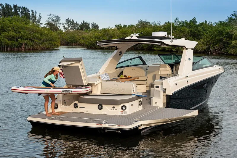 Slide: The Image of Manufacturer Provided Image: 2022 Sea Ray SLX 400 boat with a woman loading a paddleboard on the deck. - 4
