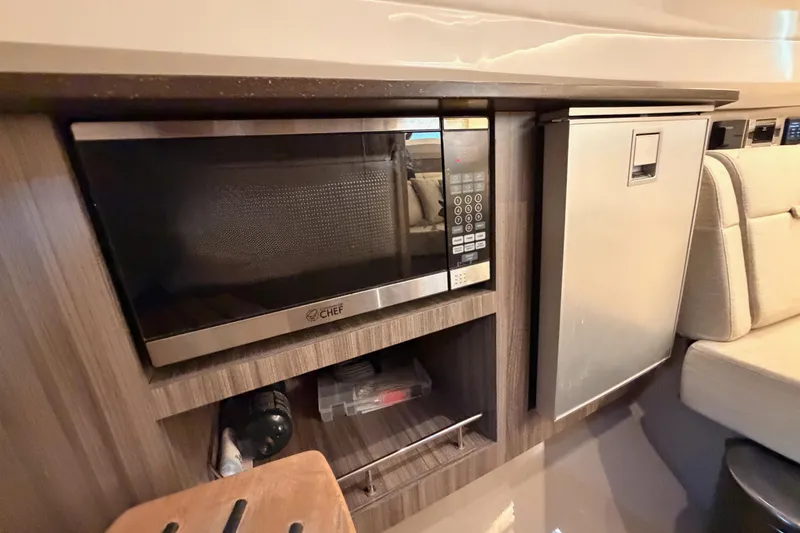 Slide: The Image of Interior of 2021 Sea Ray SLX 400 featuring a microwave and compact refrigerator. - 55