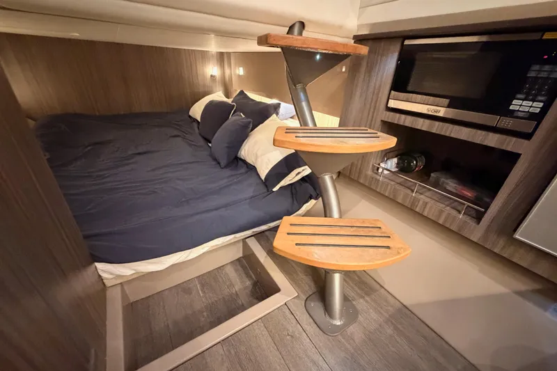 Slide: The Image of Interior of 2021 Sea Ray SLX 400 with bed, steps, and microwave. - 64