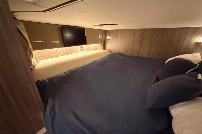 Slide: The Image of Luxurious cabin interior of 2021 Sea Ray SLX 400 with cozy bedding and ambient lighting. - 66