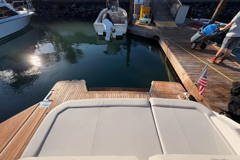 Slide: The Image of 2021 Sea Ray SLX 400 yacht docked, featuring spacious deck and American flag. - 77