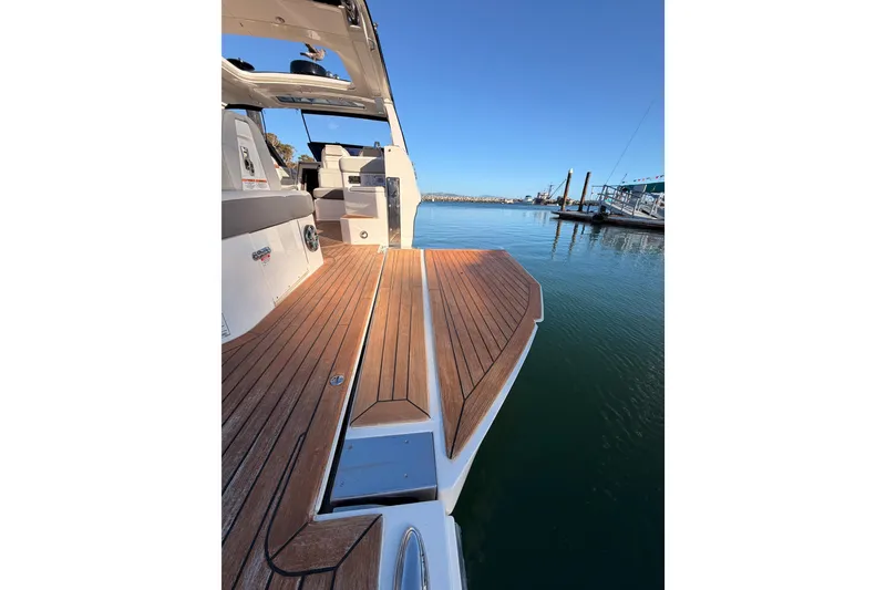 Slide: The Image of 2021 Sea Ray SLX 400 boat with teak deck, docked in a serene marina. - 79