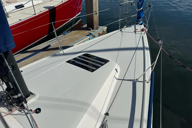 Slide: The Image of 2014 J Boats J/88 sailboat deck with rigging, docked beside a red boat. - 16