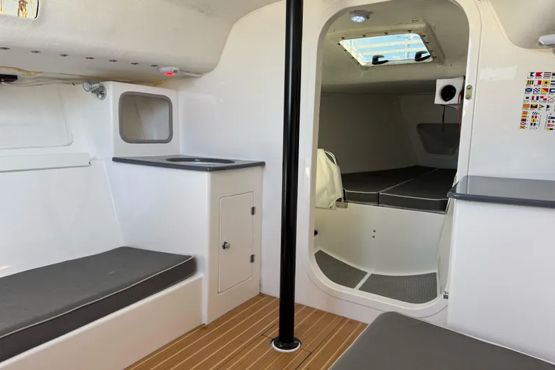 Slide: The Image of Interior of 2014 J Boats J/88 sailboat, featuring seating, storage, and a compact cabin area. - 22