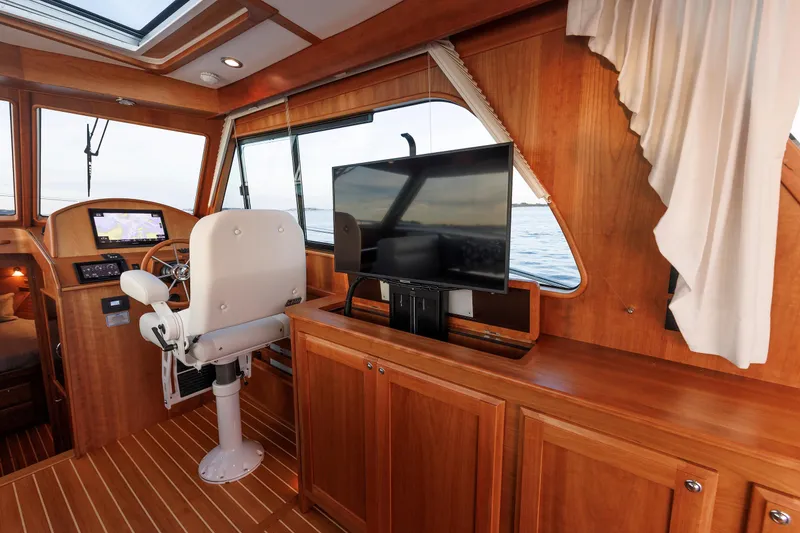 Slide: The Image of Interior of 2022 Sabre 38 SE yacht with helm, TV, and wooden cabinetry. - 14