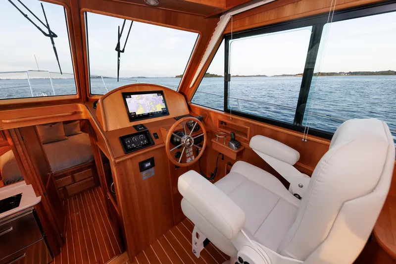 Slide: The Image of 2022 Sabre 38 SE yacht interior with helm, navigation screen, and white captain's chair. - 16