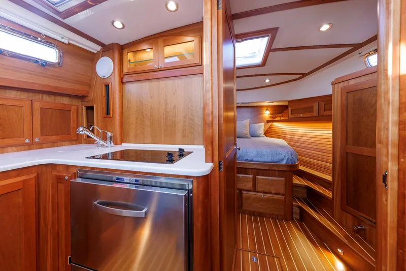 Slide: The Image of Interior of 2022 Sabre 38 SE yacht featuring kitchen and cozy bedroom. - 20