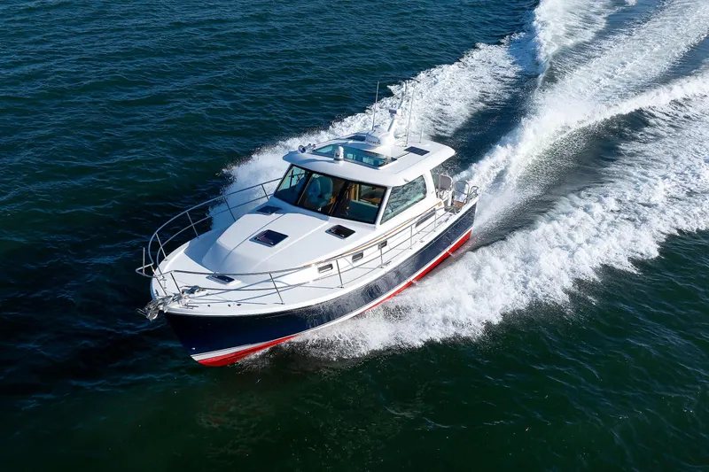 Slide: The Image of 2022 Sabre 38 SE yacht cruising on open water, creating a dynamic wake. - 48