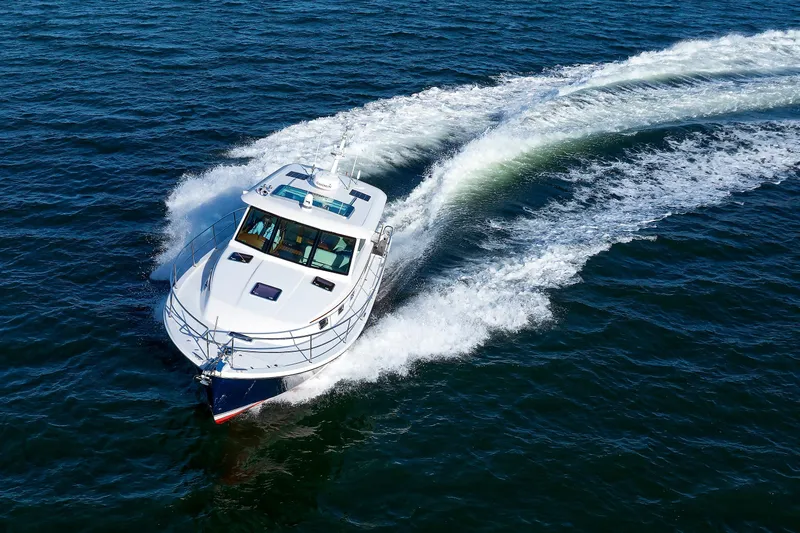 Slide: The Image of 2022 Sabre 38 SE yacht cruising on open water, creating a dynamic wake. - 49