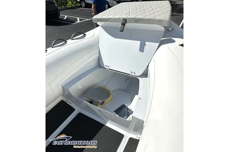 Slide: The Image of Manufacturer Provided Image: Open storage compartment on 2025 East Marine 300 boat, featuring cushioned seating. - 3