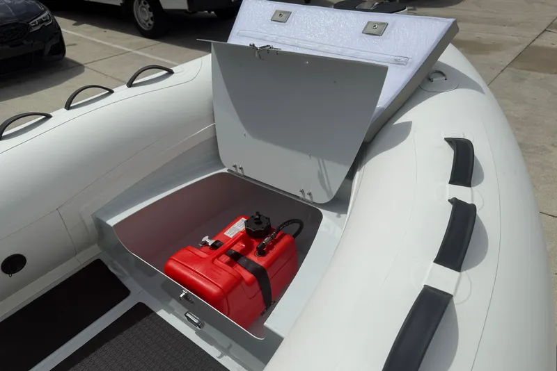 Slide: The Image of Open storage compartment in 2026 East Marine 300 boat with red fuel tank. - 6