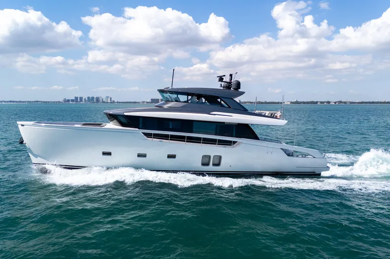 Slide: The Image of 2019 Sanlorenzo SX76 yacht cruising on blue water with city skyline in background. - 3