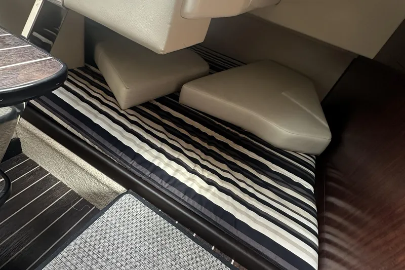 Slide: The Image of Interior cabin of 2016 Monterey 295 Sport Yacht with striped bedding and cushions. - 11