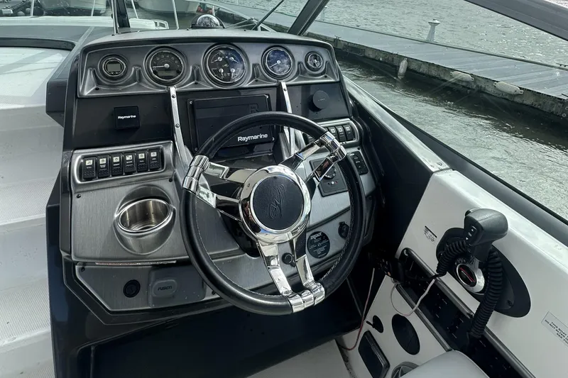 Slide: The Image of 2016 Monterey 295 Sport Yacht dashboard with steering wheel and navigation controls. - 6