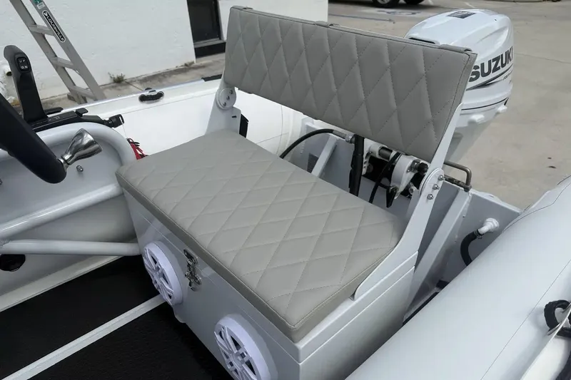 Slide: The Image of Manufacturer Provided Image: 2025 East Marine 320 inflatable boat with steering console and outboard motor on concrete surface. - 5