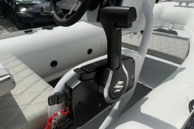 Slide: The Image of Manufacturer Provided Image: 2025 East Marine 320 boat interior with cushioned seating and Suzuki outboard motor. - 9