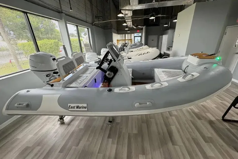 The Image of 2026 East Marine 360 inflatable boat with Suzuki outboard motor in showroom. - 0
