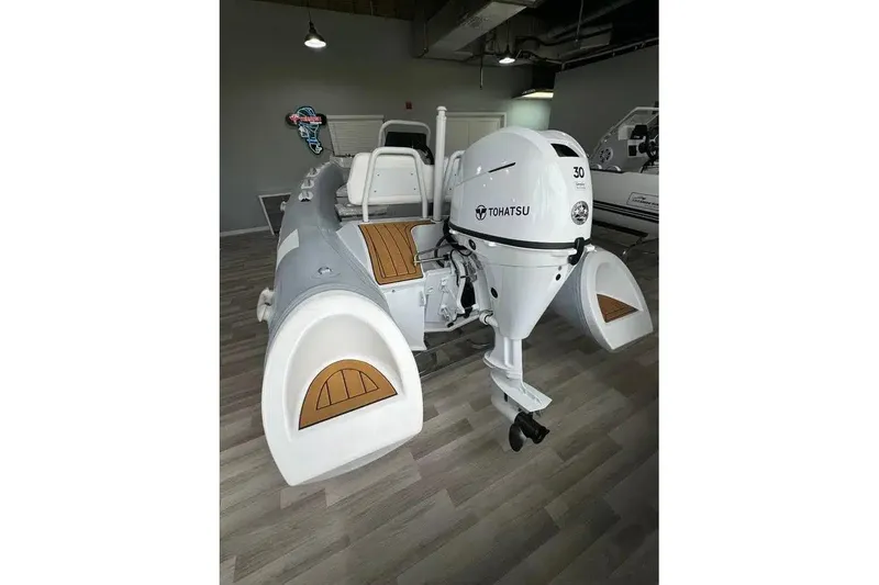 Slide: The Image of 2026 East Marine 360 inflatable boat with Tohatsu 30 outboard motor, displayed indoors. - 4