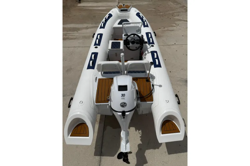 Slide: The Image of Exterior view of East Marine Boats facility with palm trees and blue awnings. - 14