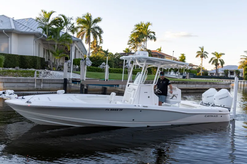 Slide: The Image of 2022 Caymas 28 HB Twin boat on a calm waterfront with palm trees. - 0